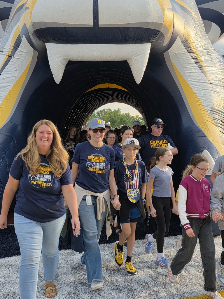 staff walking through the wildcat tunnel onto the football field.