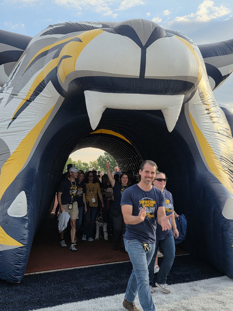 staff walking through the wildcat tunnel onto the football field.