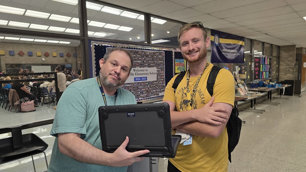 Photo of IT Professional holding up a computer. 