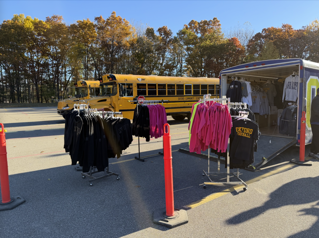 School bus with boosters shop set up next to it