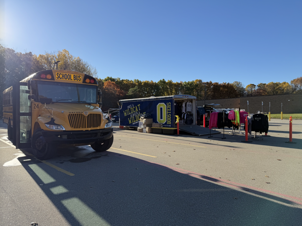 School bus with boosters shop set up next to it