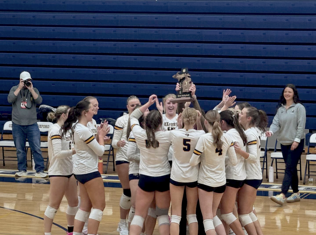 OHS Volleyball team holding up a trophy and celebrating