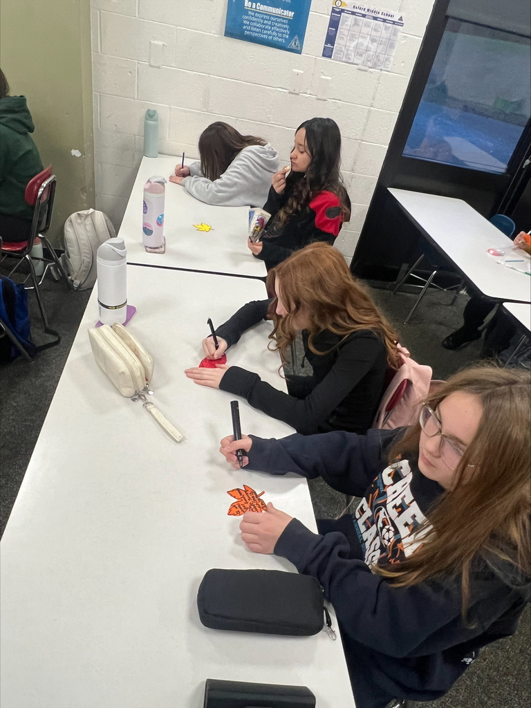 middle school students with decorated paper leaves