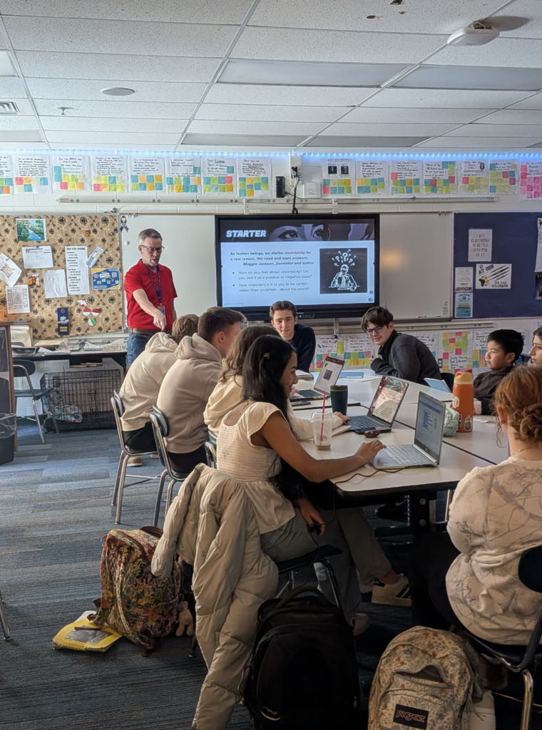 students sitting at desks and working on laptops