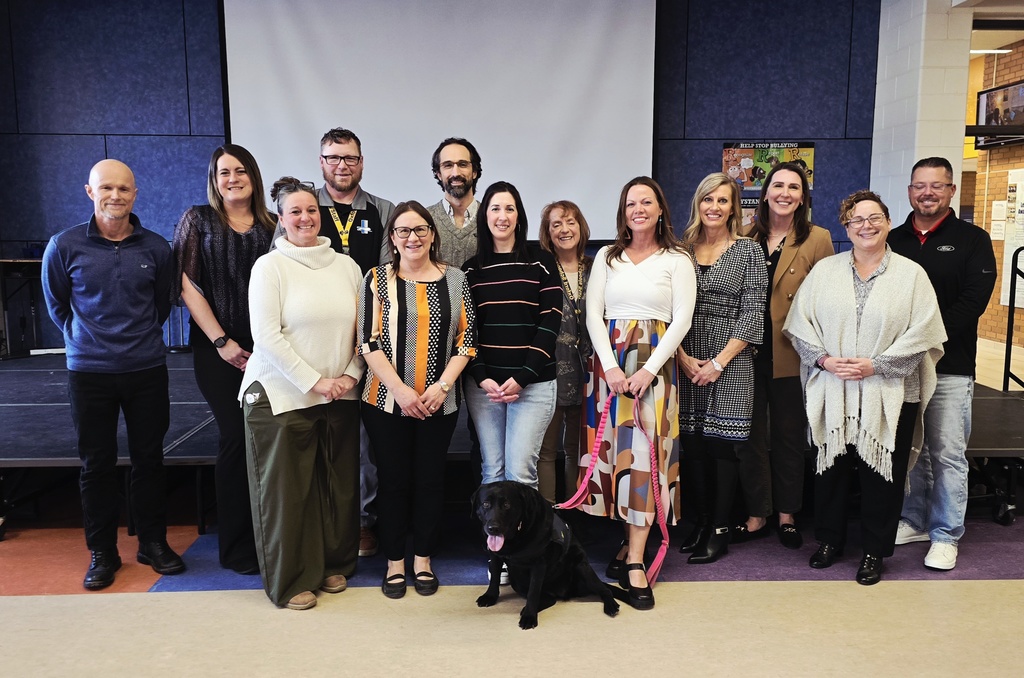 Oxford Board of Education with Teachers and Support Staff of the Year plus a black lab in the front, all smiling and facing the camera