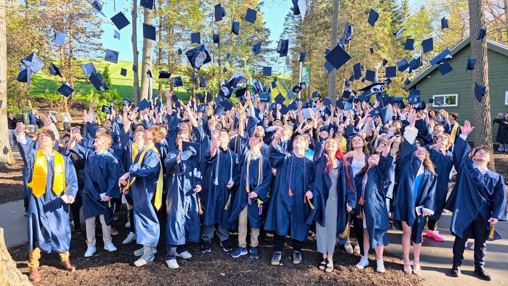 students throwing graduation caps into the air