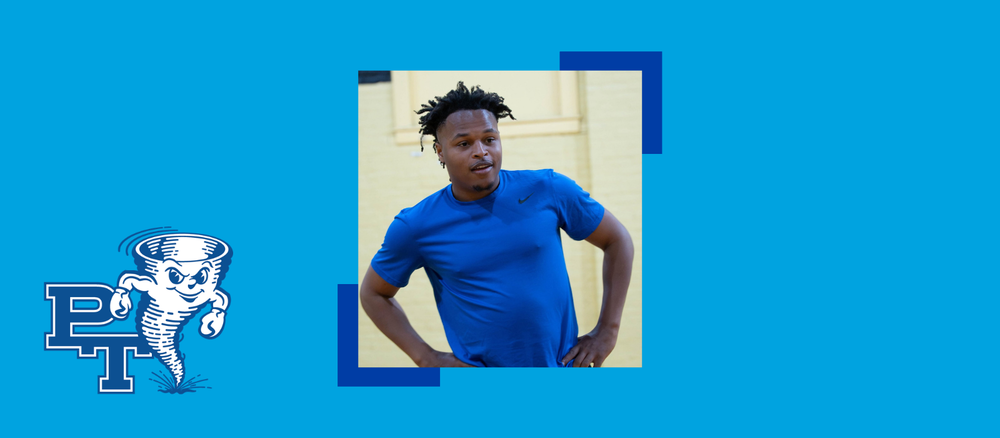 a man in a blue shirt stands with his hands on his hips