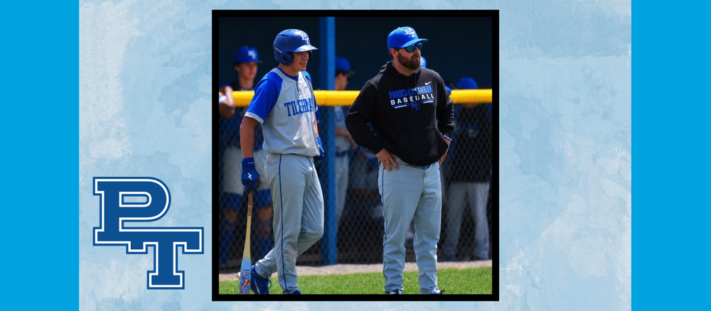 A coach and a baseball player look out at the field