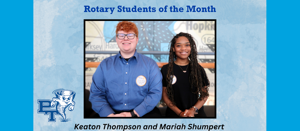 Two Students sit on a bench with a large map in the background