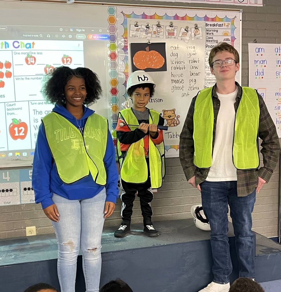 Students in work vests in front of a whiteboard