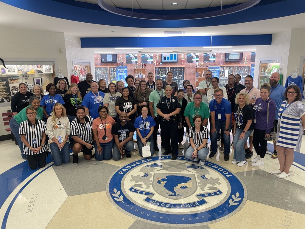 A group of teachers gather around a student resource officer