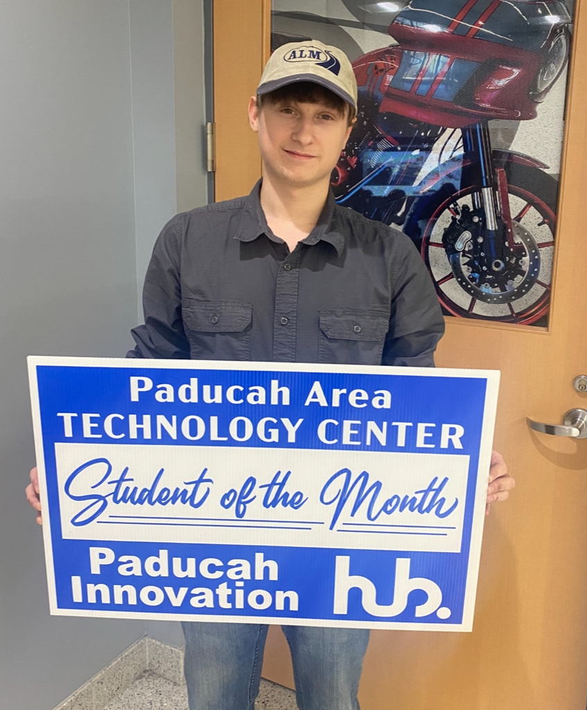 A person holds a blue sign saying "Student of the Month" at Paducah Area Technology Center.