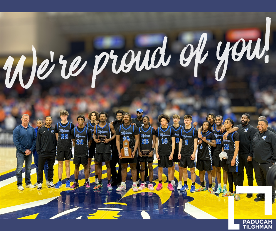 Basketball team stands as a group holding a trophy. Text reads "We're proud of you."