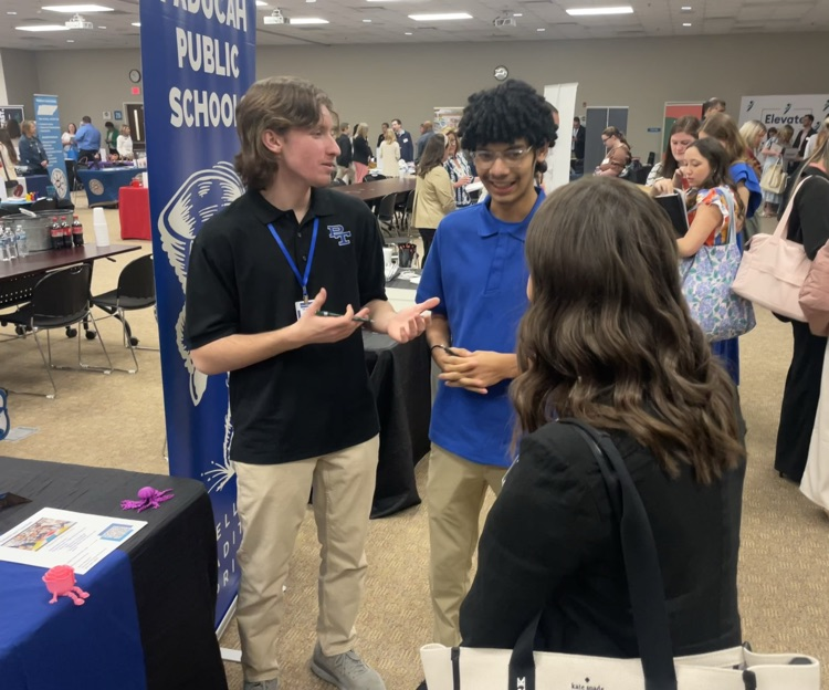 Two teenagers speaking with a woman.