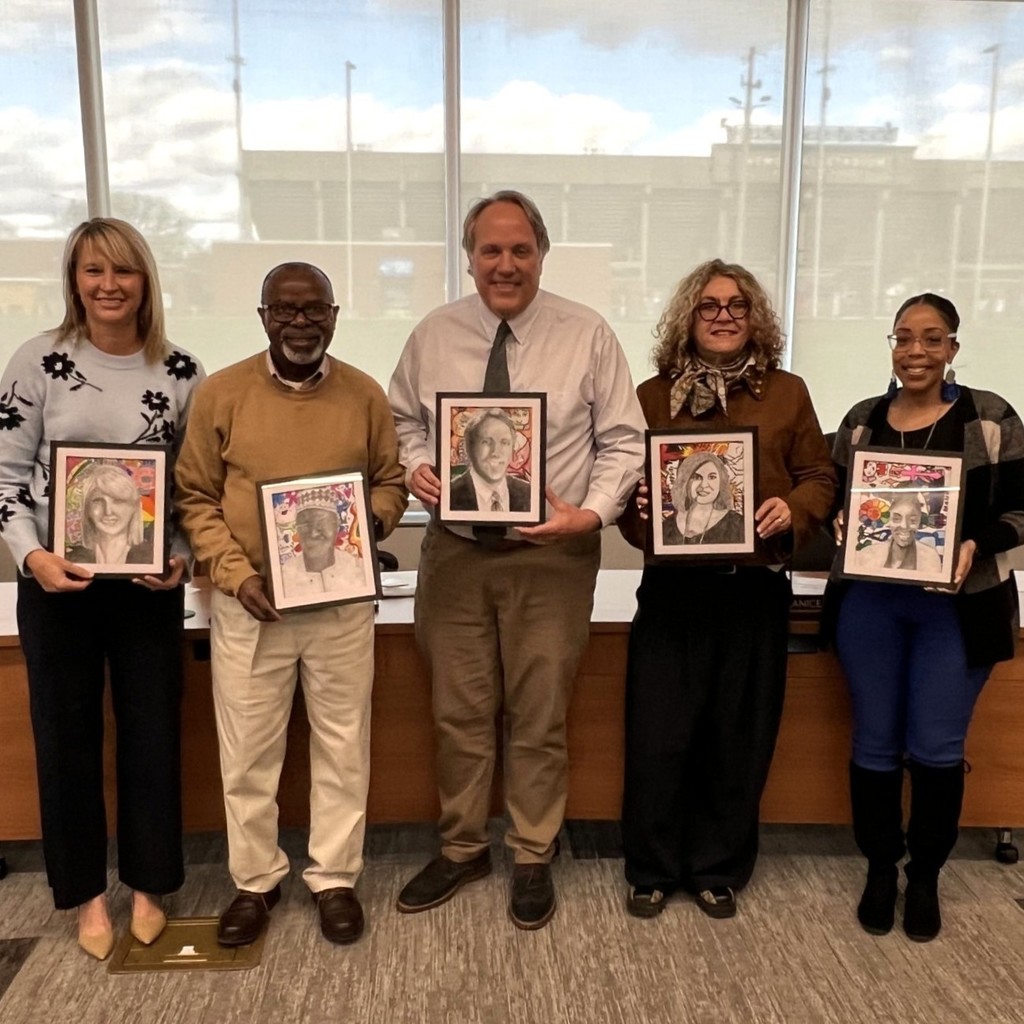 A group of adults how student-created portraits.