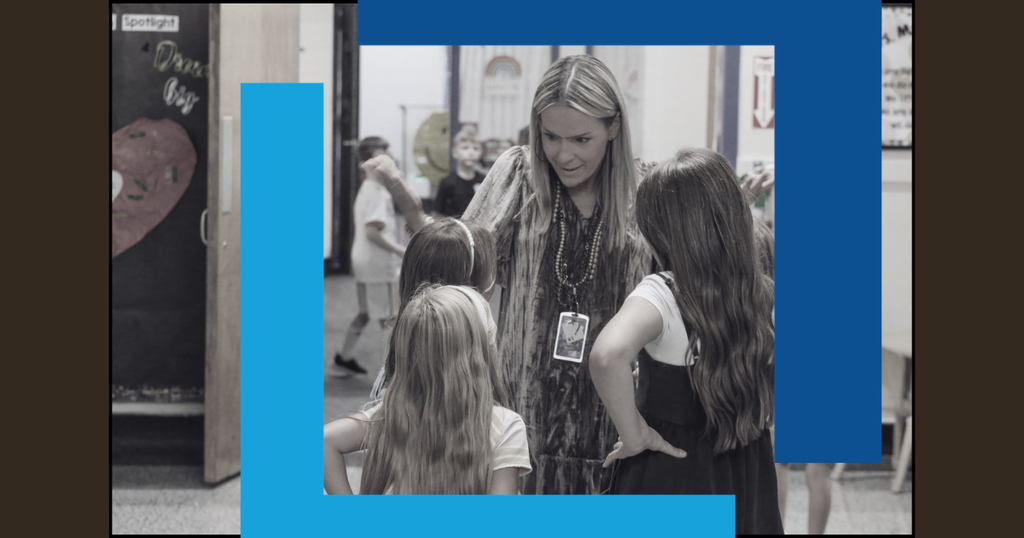 A black-and-white photograph shows a woman with long hair, surrounded by children in a school corridor.