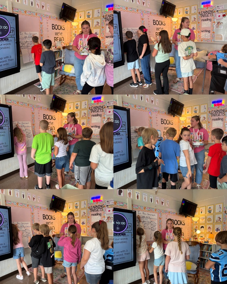  Fourth graders take turns signing their classroom agreement.