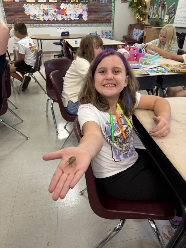 Fourth grader showing cicada shell