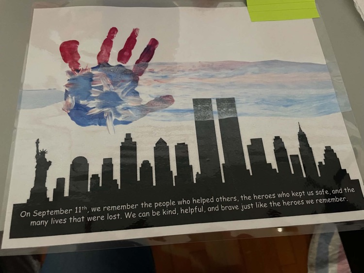 Student handprint artwork featuring red fingertips, a blue palm, and white stars above a black New York City skyline