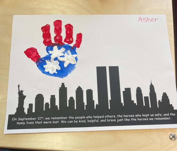 Student handprint artwork painted red, white, and blue above a black New York City skyline in remembrance of September 11.