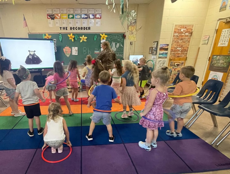 Pre-k students dance and sing in music class.