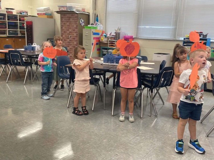 Ore-k students showing off their artwork they made in art class.