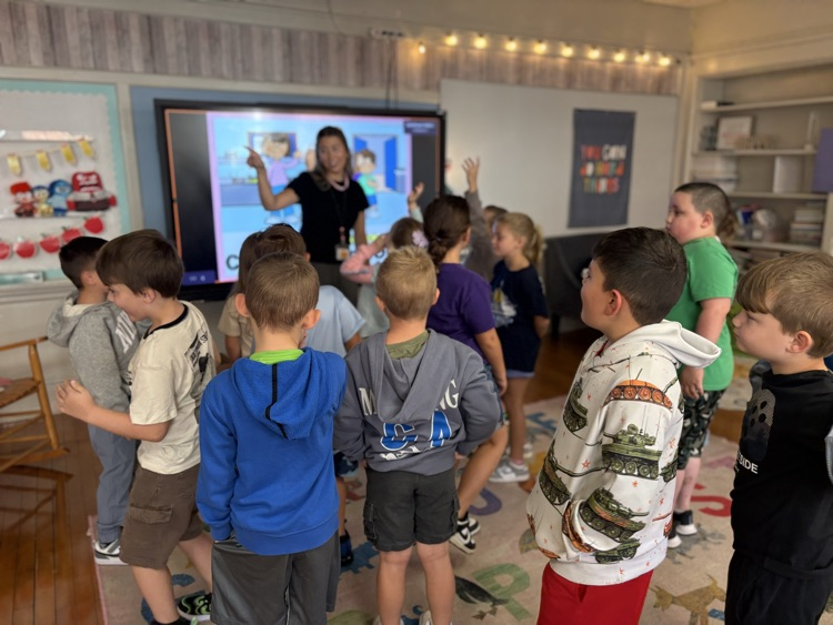 Group of first graders playing a game with their guidance counselor .