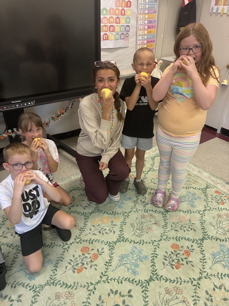 teacher with kids eating apples 