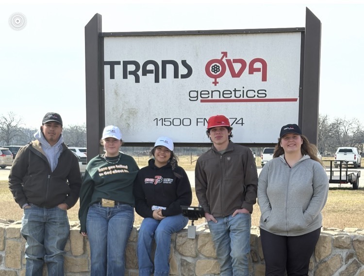 five students posed in front of Trans OVA sign