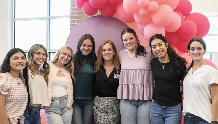 group of girls on front of pink balloons