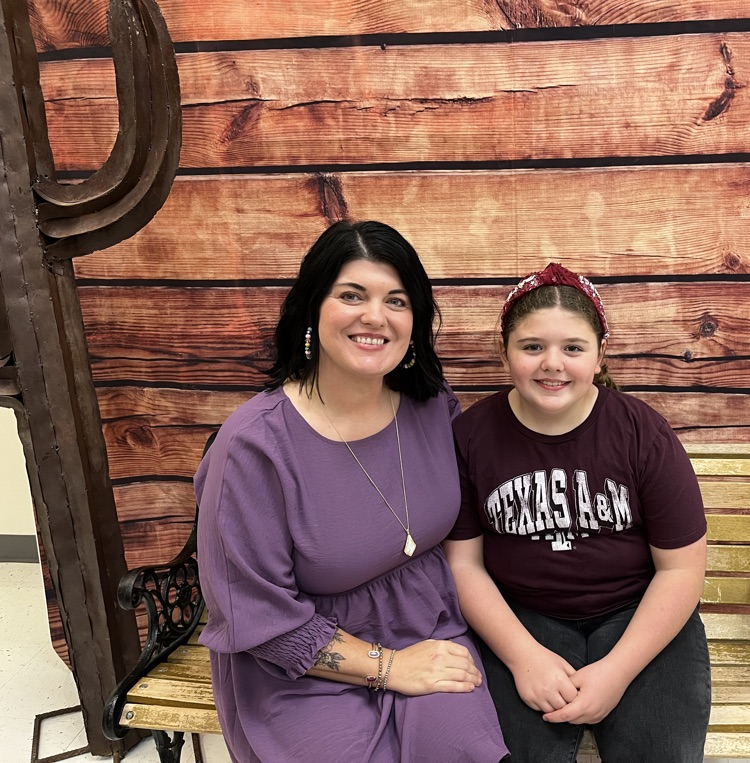 Parent with student at table with red and white checkered table cloth eating breakfast