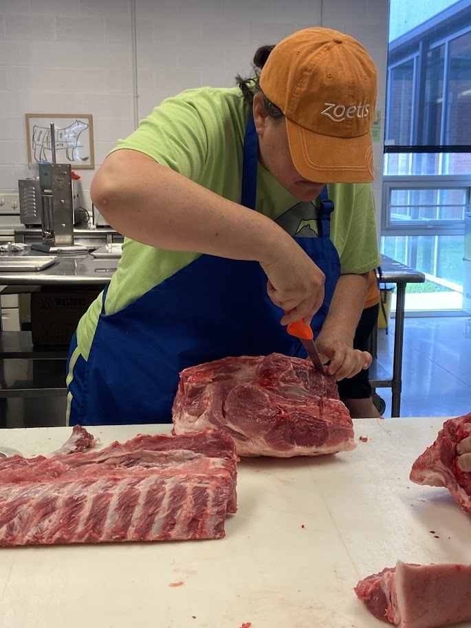 Ag teacher learning how to debone a pig