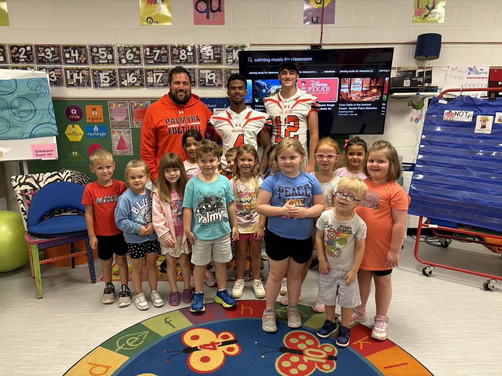 Kindergarten listening to football players and coach read books