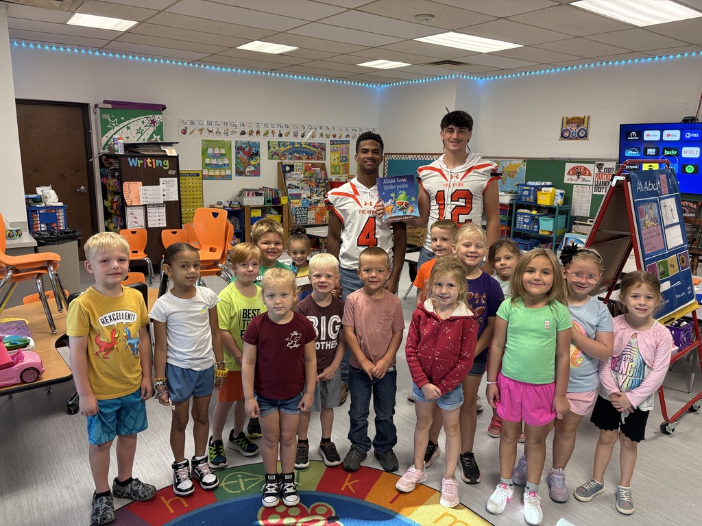 Kindergarten listening to football players and coach read books