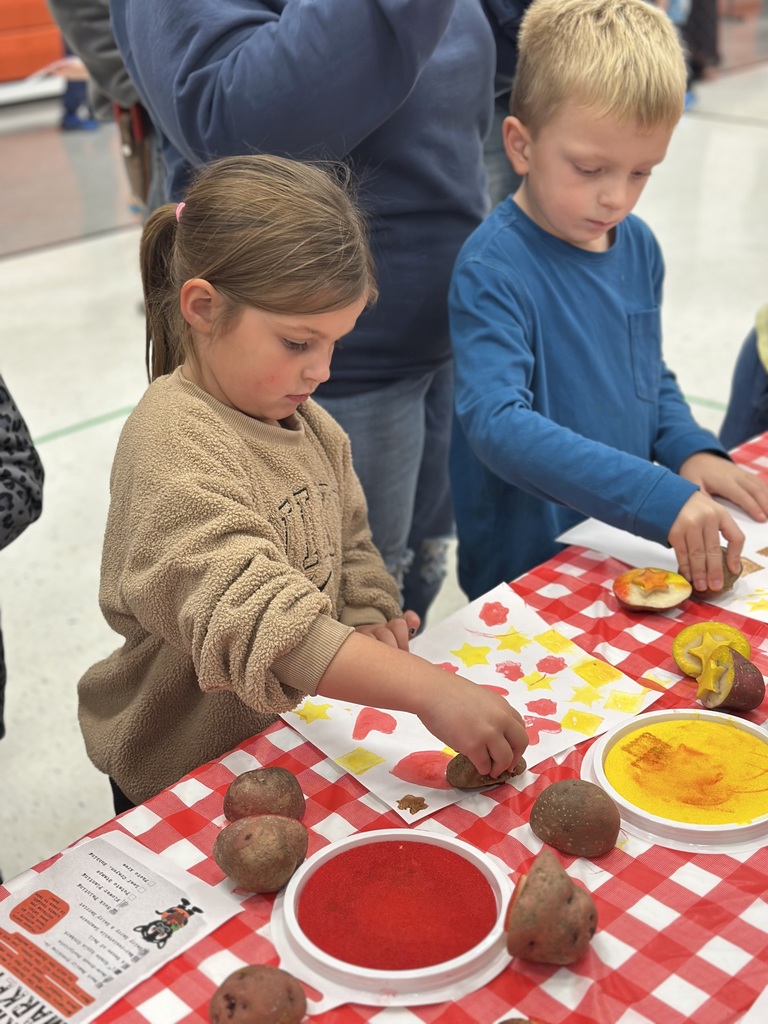 1st grade students and families at open house showing off their projects
