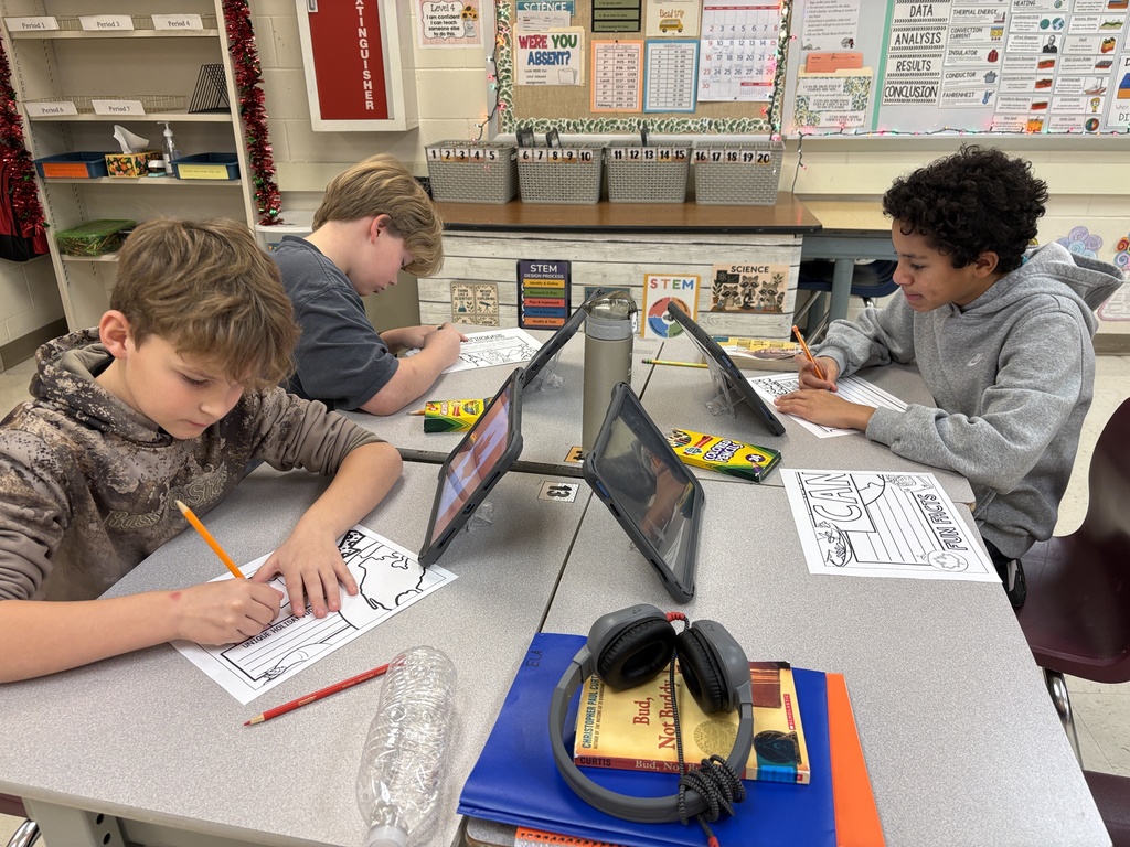 Students in STEM class work on Christmas Around the World display