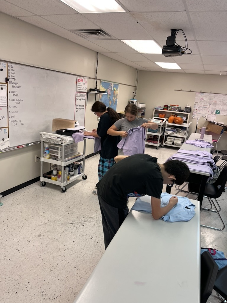 students making shirts for powderpuff homecoming rally