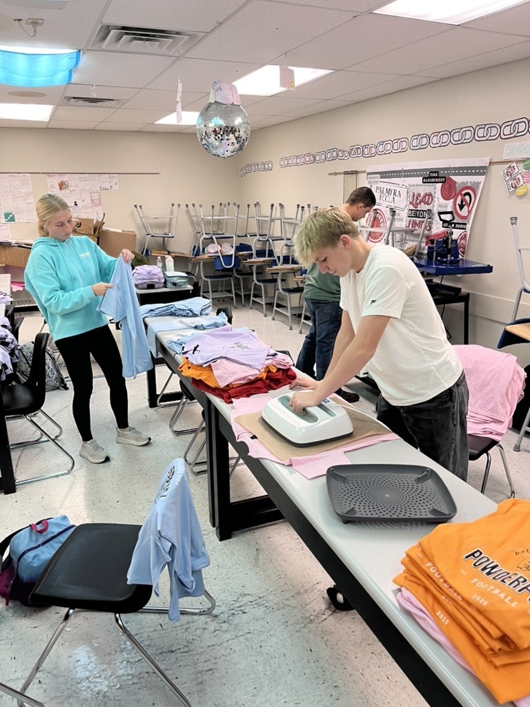 students making shirts for powderpuff homecoming rally