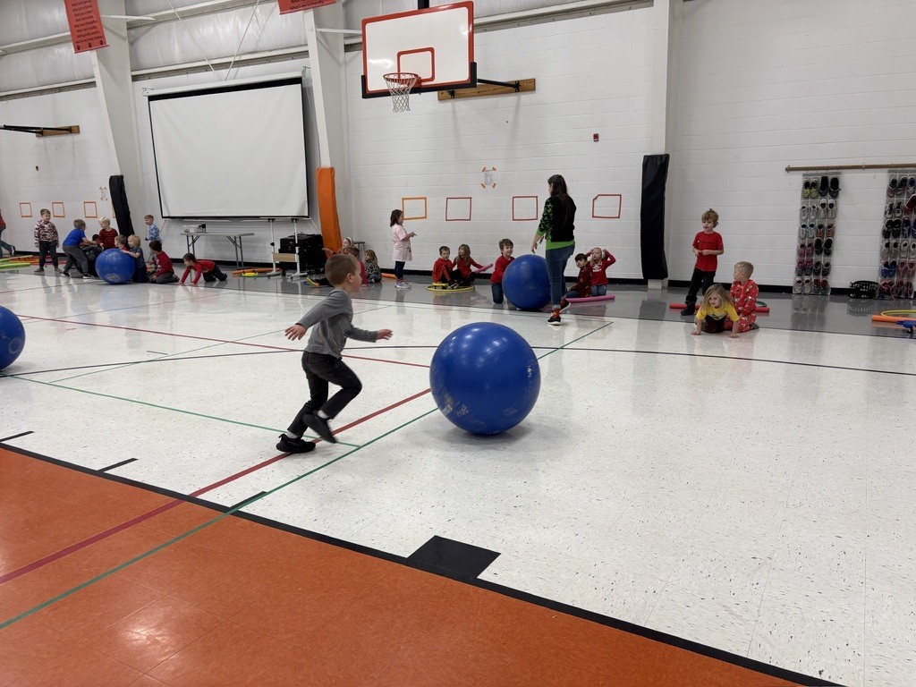 PES Students play reindeer games, rolling giant snowballs in gym