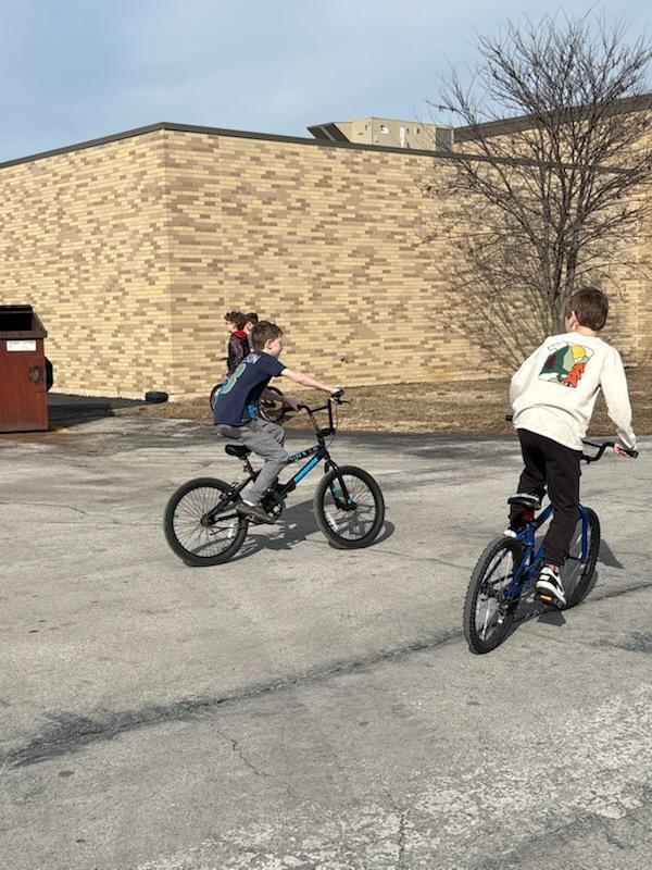 PES 4th grade students enjoying outside time riding their bikes and scooters