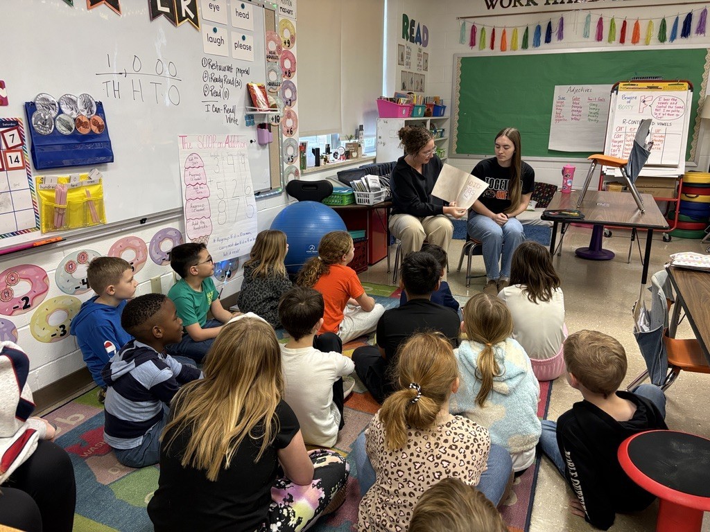 Ava and Maya reading to a classroom