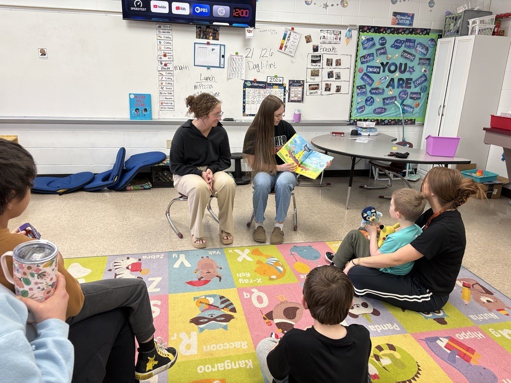 Ava and Maya reading to a classroom