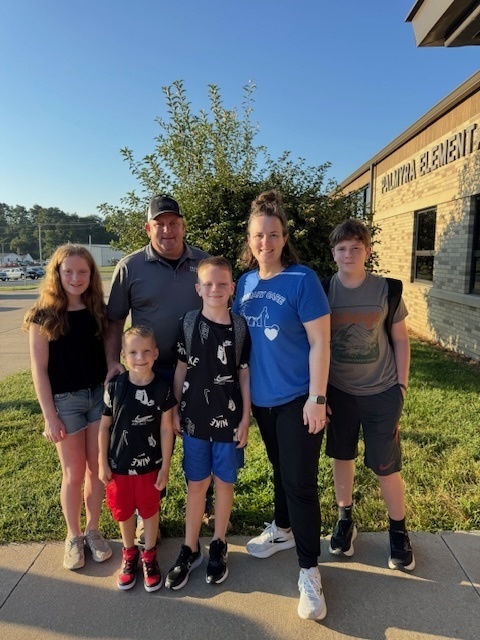 Amber Gottman, board member, and family in front of Palmyra Elementary school