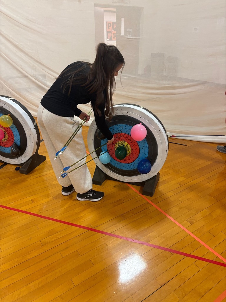 student gathering arrows after shooting archery in Integrated Science