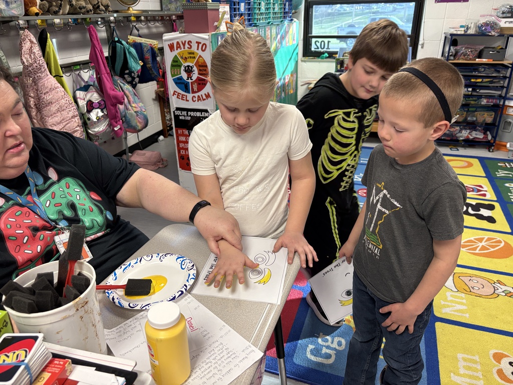 Ms Burwinkle and student doing art project in kindergarten