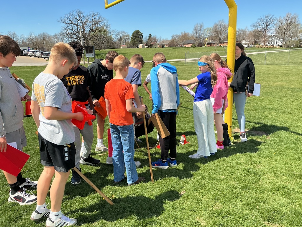 science students studying the scale of the solar system outside on football field