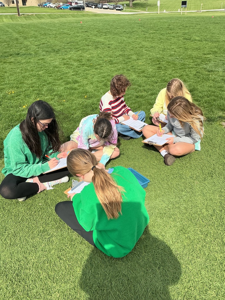 science students studying the scale of the solar system outside on football field