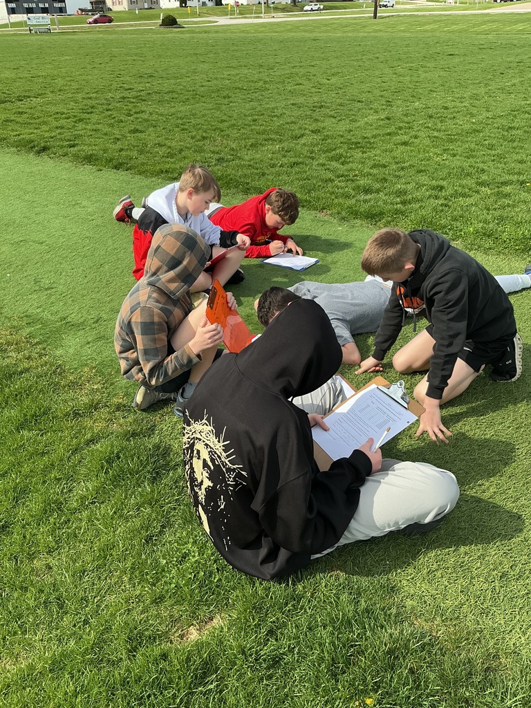 science students studying the scale of the solar system outside on football field