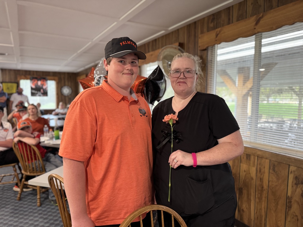 Senior night recognition, student with parent holding orange carnation