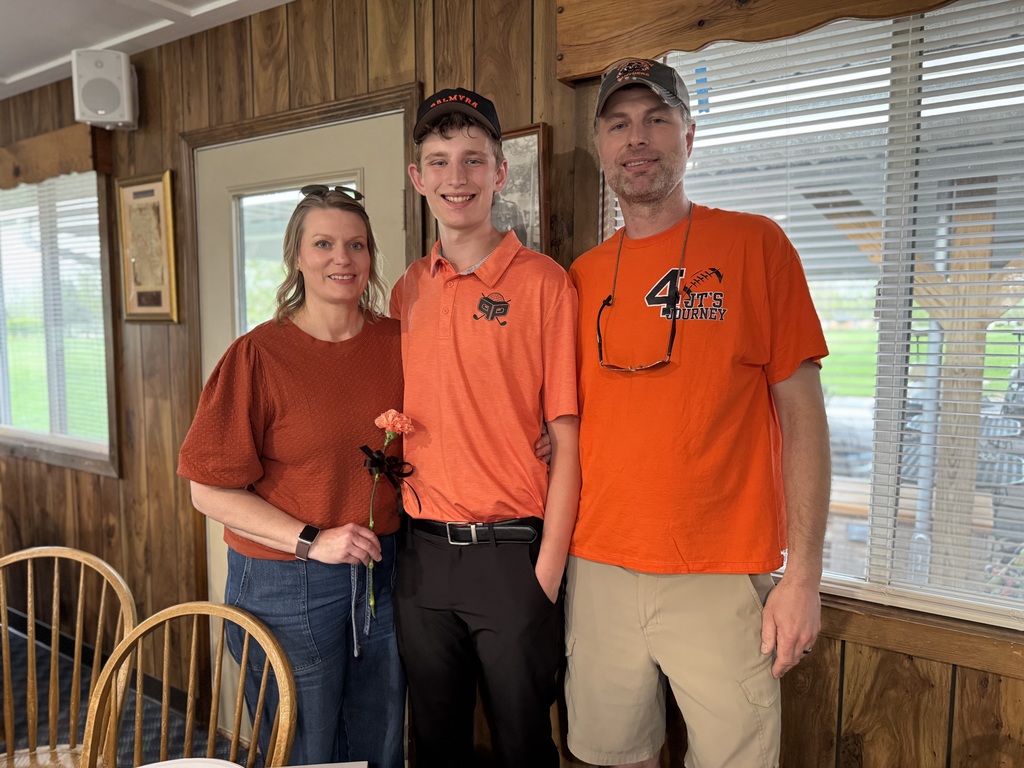Senior night recognition, student with parents holding orange carnation